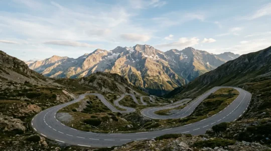 Vista panoramica di un passo alpino con tornanti stretti e pendenze ripide durante una giornata serena