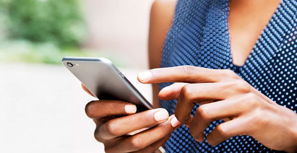 Primo piano di una mano che tiene uno smartphone con calendario digitale visibile sullo schermo completamente sfocato