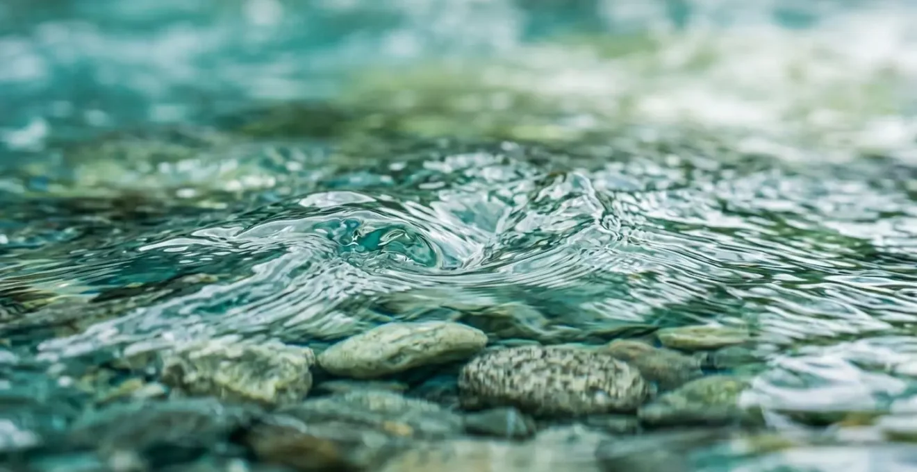 Dettaglio macro della superficie dell'acqua di un fiume da rafting con texture cristallina e riflessi naturali