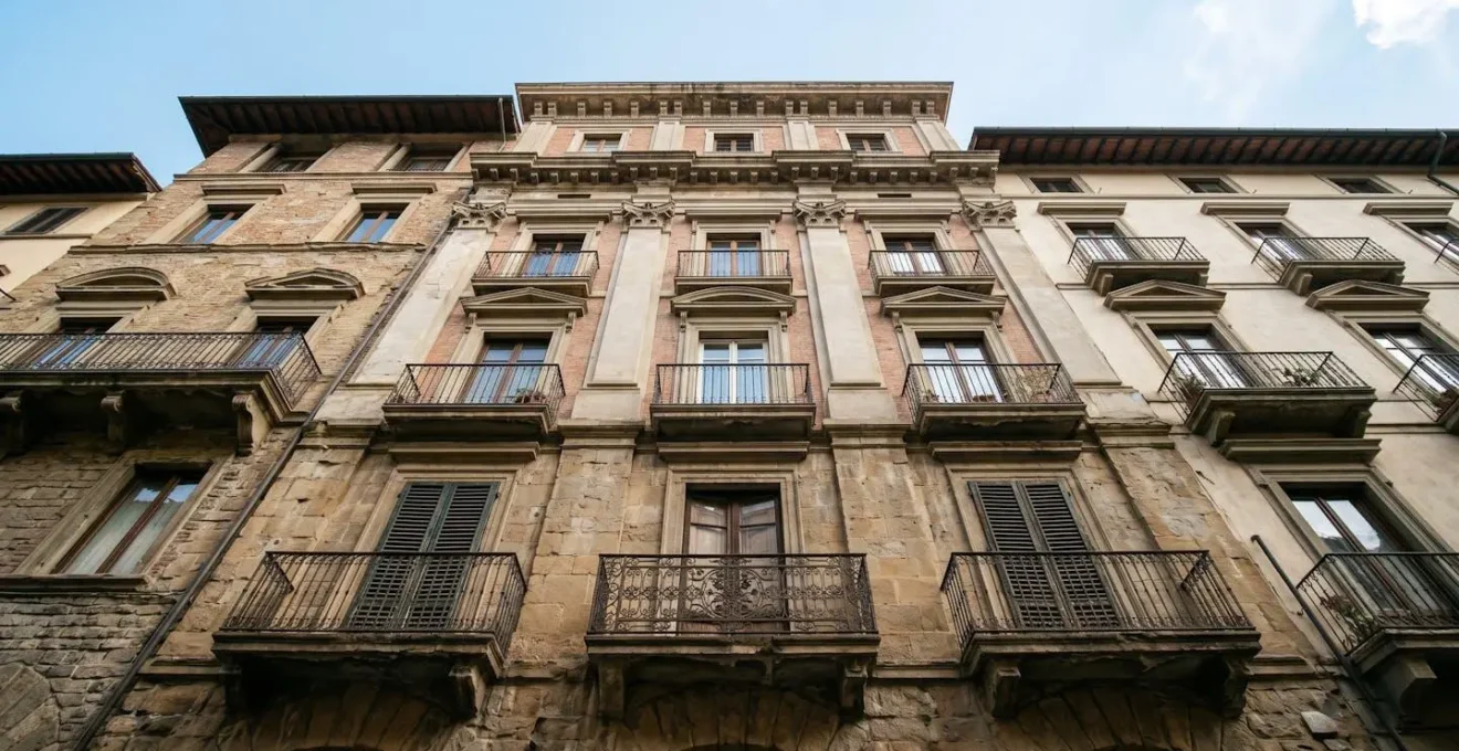 Dettagli architettonici di un edificio urbano visti dal basso verso l'alto mostrando diversi strati temporali